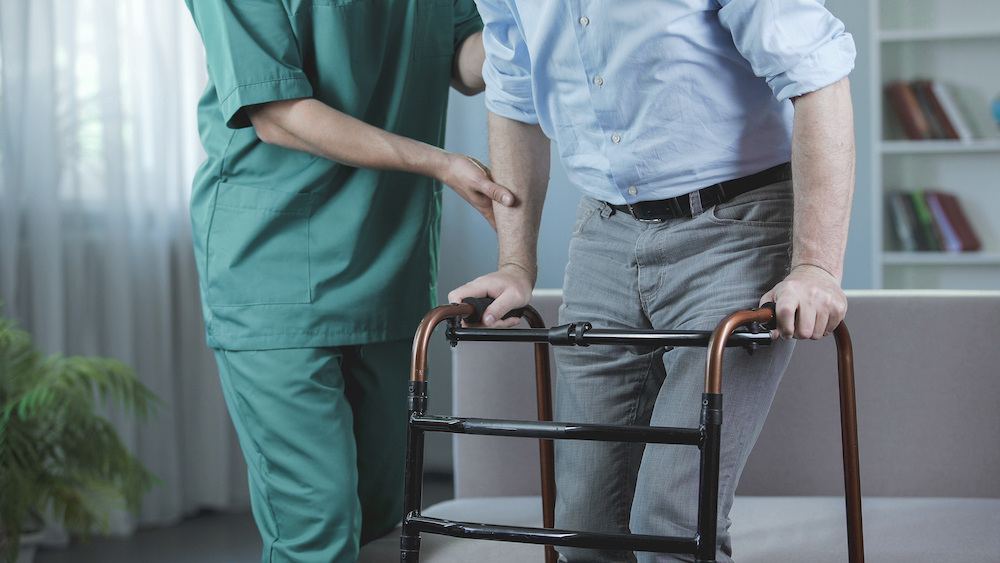 nurse assisting an elderly man in a senior care center